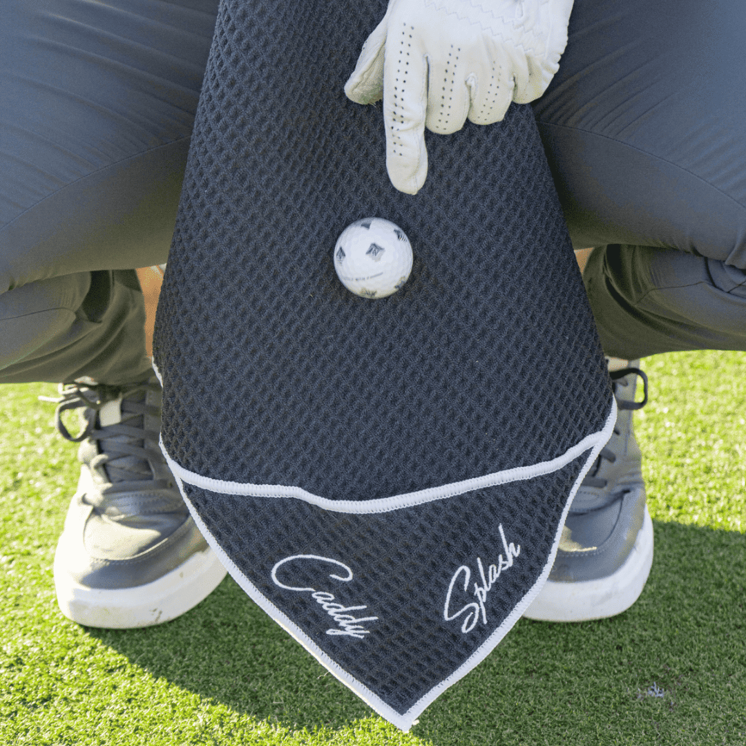 Golf towel with a golf ball and gloved hand on grass